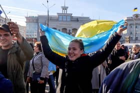 People celebrate in the centre of Kherson, Ukraine, yesterday after it was retaken from Russian forces (Picture: Oleksandr Gimanov/AFP via Getty Images)