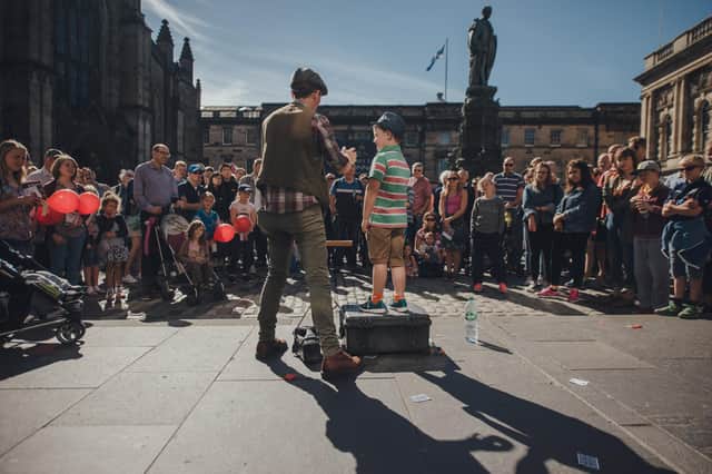 Huge crowds traditionally flock to Edinburgh city centre for free street theatre performances in August. Picture: David Monteith Hodge