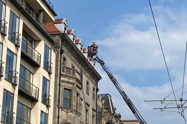 Firefighter pictured up an aerial ladder as emergency services respond to incident outside Debenhams in Edinburgh picture: Lisa Ferguson/JPI Media