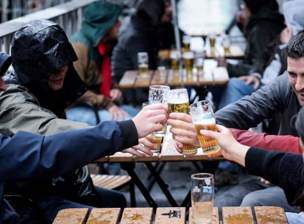 Friends toast each other as they drink a beer on a terrace in Brussels, on May 8, 2021, as the Belgium government eased the restrictions put in place to curb the spread of the coronavirus Covid-19. (Photo by Kenzo TRIBOUILLARD / AFP) (Photo by KENZO TRIBOUILLARD/AFP via Getty Images)
