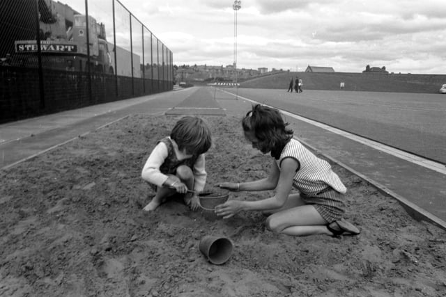 Two little girls making sandpies in the Commonwealth Games long-jump sandpit at Meadowbank stadium in July 1970.