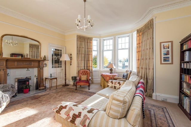 The Corstorphine property's large living room with bay window and fireplace.