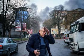 An injured man stands on a street after Russian shells hit the Ukrainian city of Kherson on Saturday. Five were killed and 20 injured in the attack (Picture: Dimitar Dilkoff/AFP via Getty Images)