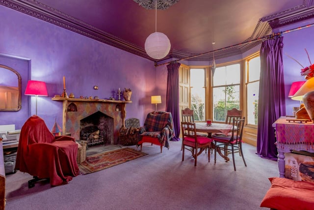 The elegant bay windowed sitting room has ornate cornicing and a bespoke fireplace.