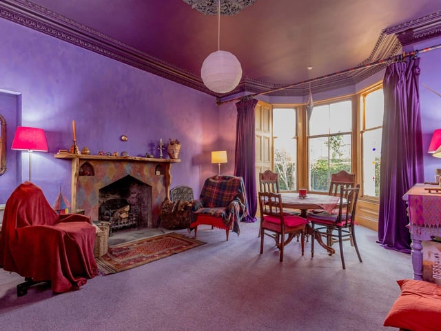 The elegant bay windowed sitting room has ornate cornicing and a bespoke fireplace.