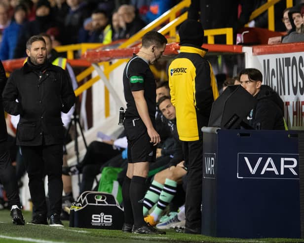 Lee Johnson watches on as referee David Munro studies the VAR monitor during Hibs' 4-1 defeat by Aberdeen