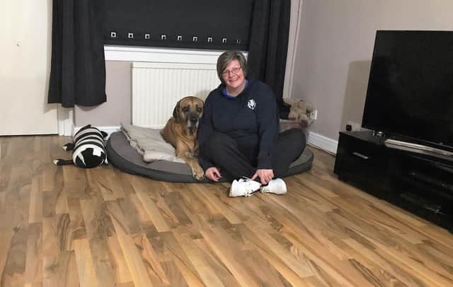 Ali McVie and her dog Sam with the new flooring in their home.