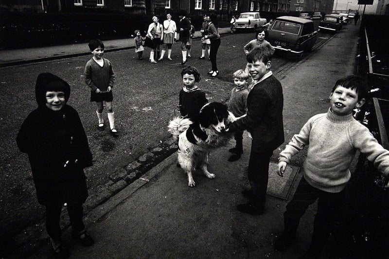 Children from the Niddrie area of Edinburgh playing on the street with a dog in the 1960s.