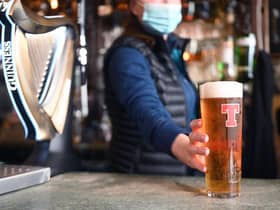 A bar person serves up a pint of Tennants lager. Picture: John Devlin