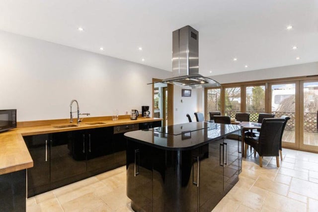 The modern kitchen benefits from a range of integrated appliances including an induction hob, extractor hood, mid-height oven, microwave, an electric oven, dishwasher and fridge-freezer.