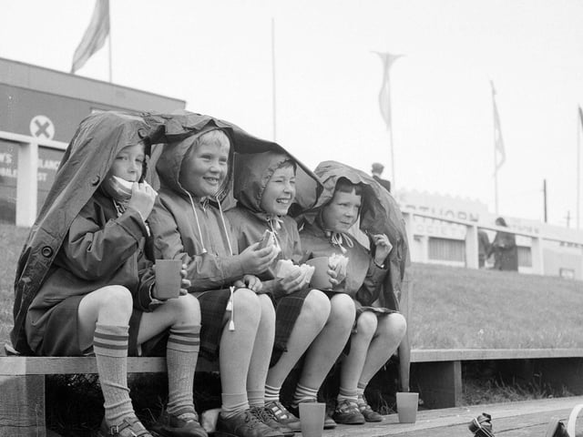 David Fisher, Fiona Armstrong, Mary Fisher and Lisa Fisher from Plean Mill, near Stirling, enjoy their packed lunches under a plastic mac at the Royal Highland Show in 1965.