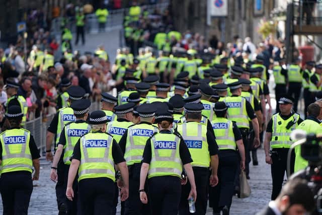 Police make their way along a street ahead of the coffin carrying Her Majesty Queen Elizabeth II from St Giles' Catheral (Photo by Ian Forsyth/Getty Images)