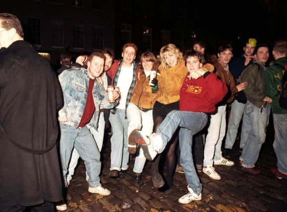 New Year party goers can be seen here having a knees-up at the Tron Kirk in Edinburgh on Hogmanay, 1990.