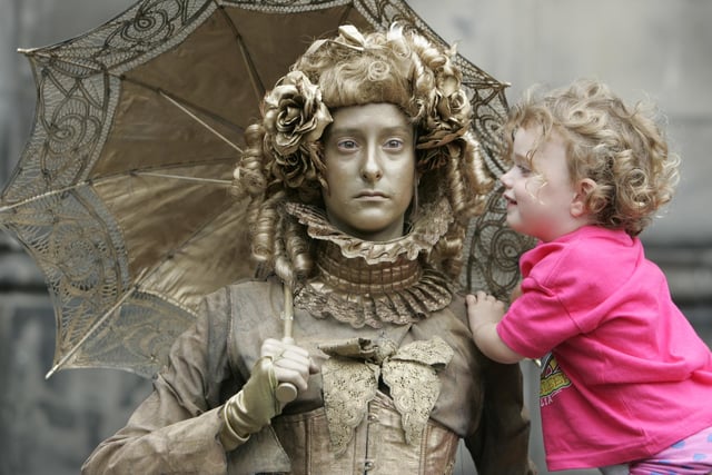 Human statue street performer 'Lady Gold' with two-year-old Rose Meighan at The Edinburgh Fringe in 2013.