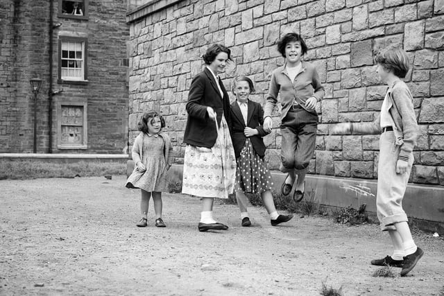 Girls playing skipping ropes in Lapicide Place (August 1957).