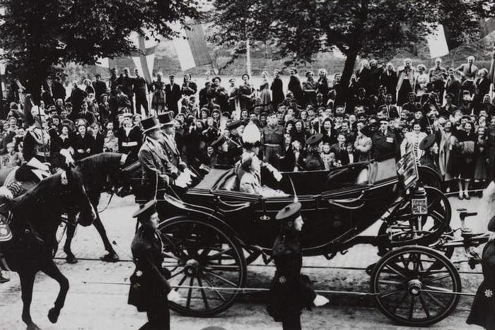 The Queen and Duke of Edinburgh travel by carriage in a procession through the streets of Edinburgh with the Honours of Scotland.