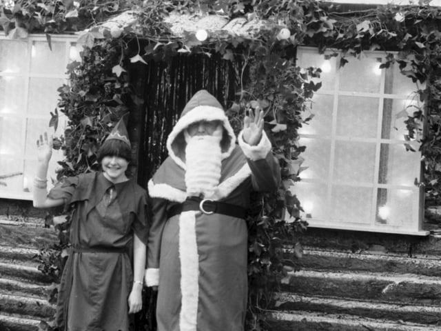 Santa Claus and one of his elf helpers outside his new grotto in Princes Street Gardens in December 1985.