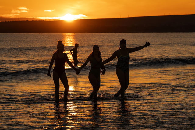 As the sun rose above Edinburgh, one group of women held hands as they waded through the icy water.