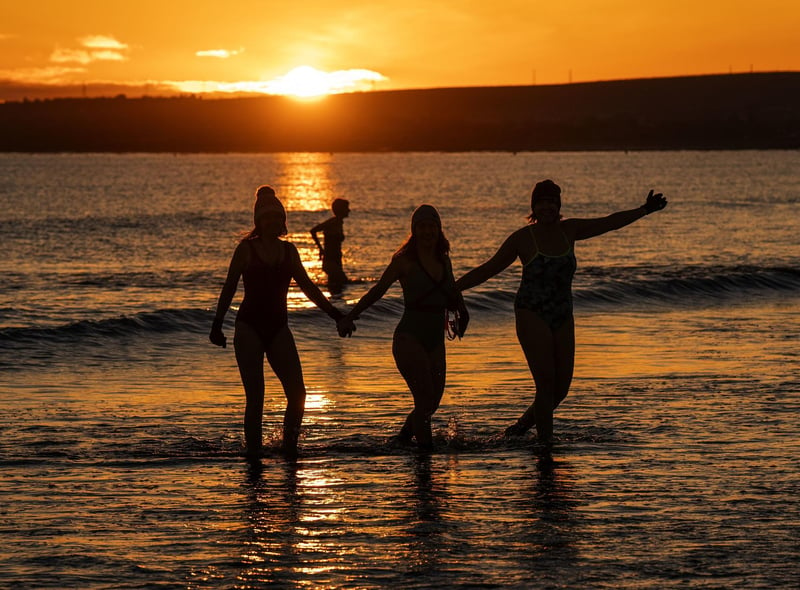As the sun rose above Edinburgh, one group of women held hands as they waded through the icy water.
