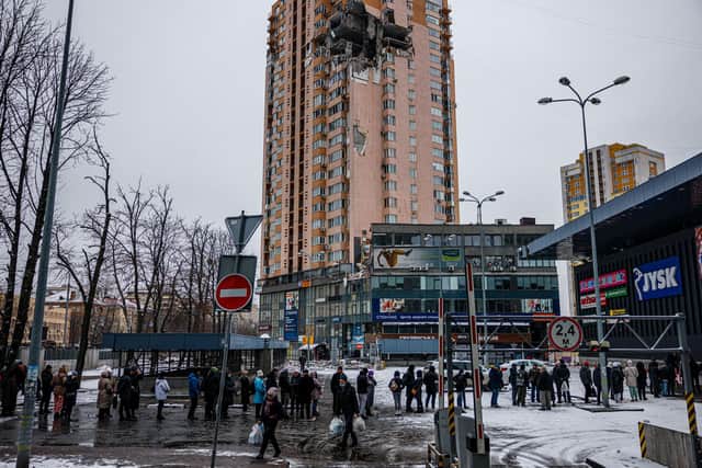 People queue up to buy food from a supermarket near a building damaged by Russian missiles in Ukraine's capital Kyiv (Picture: Dimitar Dilkoff/AFP via Getty Images)