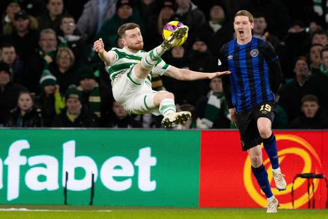 Celtic's Anthony Ralston with an acrobatic attempt on goal as Hearts defender Kye Rowles looks on.