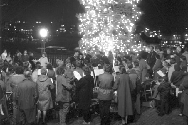 Carol singers surround the traditional  Christmas tree (a present from Norway) at the Mound in Edinburgh, November 1987.