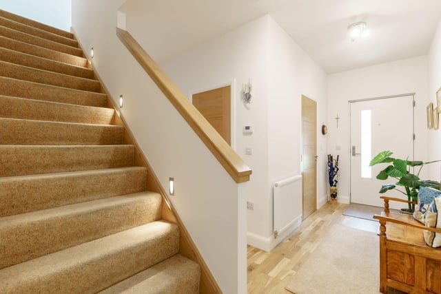 The welcoming hallway, with a storage cupboard and downstairs toilet. The sale includes luxury fittings including gas central heating, double glazed windows, designer radiators, solid wood floors and doors, integrated lighting, high quality bathroom and kitchen fittings. There is also a front paved garden area with planters and an allocated parking space.