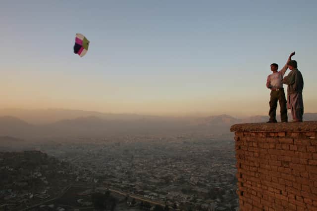Boys fly a kite on a hill overlooking Kabul (Picture: Paula Bronstein/Getty Images)