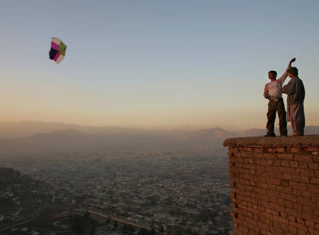 Boys fly a kite on a hill overlooking Kabul (Picture: Paula Bronstein/Getty Images)