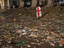 A lone fan walks amongst litter strewn on the ground in front of St Martin-In-The-Fields church in Trafalgar Square, London, after Italy beat England on penalties to win the Euro 2020 final (Picture: Dominic Lipinski/PA)
