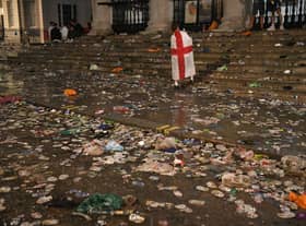 A lone fan walks amongst litter strewn on the ground in front of St Martin-In-The-Fields church in Trafalgar Square, London, after Italy beat England on penalties to win the Euro 2020 final (Picture: Dominic Lipinski/PA)