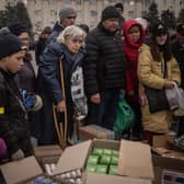 People in newly liberated Kherson crowd around volunteers to receive humanitarian food (Picture: Chris McGrath/Getty Images)