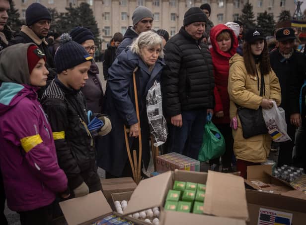 People in newly liberated Kherson crowd around volunteers to receive humanitarian food (Picture: Chris McGrath/Getty Images)