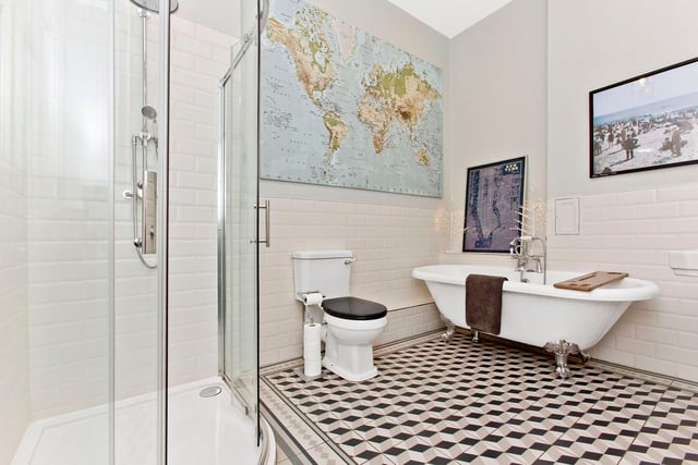 The beautifully styled family bathroom is presented with the same flooring as the vestibule and hall,