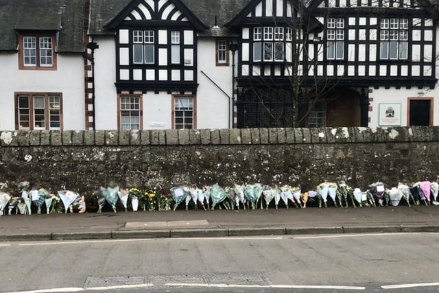 Floral tributes line Whitehouse Road