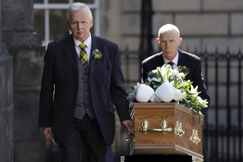 White boxing gloves lie on the coffin as it arrives for the funeral