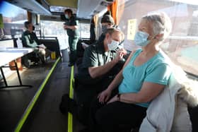 Paramedic Andrew Parker gives the vaccine to Elizabeth and Sandy Robertson inside a holiday coach outside Culloden Medical Practice near Inverness, Scotland, on 11 February - it is being used by the Scottish Ambulance Service as a mobile coronavirus vaccination centre picture: PA/Andrew Milligan