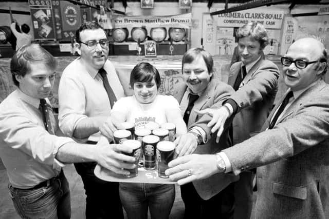 Drinkers help themselves to a pint at a beer festival in the Caledonian Brewery in May 1985