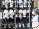 A woman wearing a protective face mask walks past a shop selling masks in Edinburgh city centre