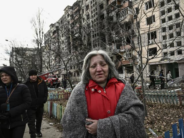 A woman walks beside a block of flats in Kyiv that was destroyed by shelling on Monday (Picture: Aris Messinis/AFP via Getty Images)