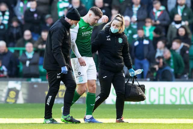 Kevin Nisbet leaves the pitch with Hibs club doctor Duncan Reid and physiotherapist Alix Ronaldson following his injury against Celtic