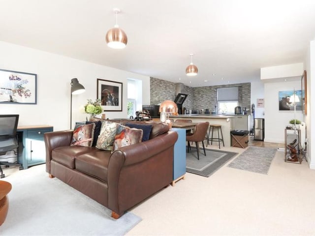 This photo demonstrates the open-plan nature of the main living and dining area at the Shirland property. In the background is the kitchen, while in the foreground is a sitting area.