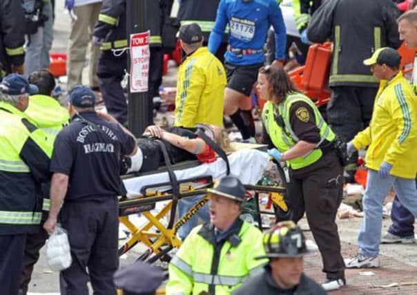 Rescue workers help the injured near the finish line. Picture: Boston Herald