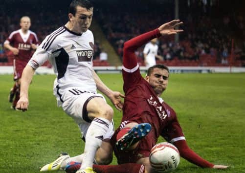 Hearts' David Smith sees his cross closed down by Clark Robertson. Picture: SNS