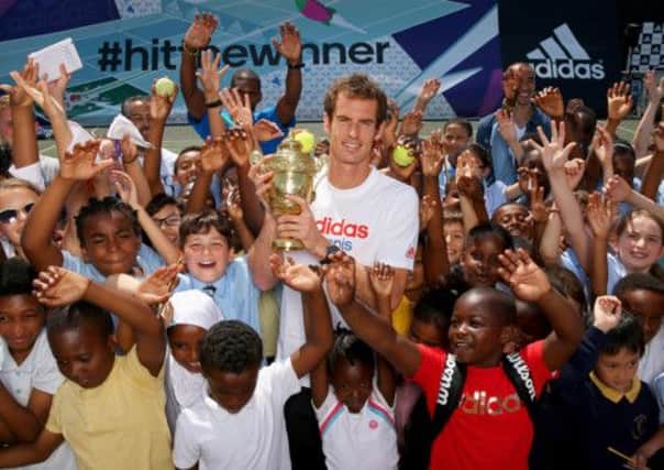 Andy Murray showing his replica trophy to children in Kennington. Picture: Getty