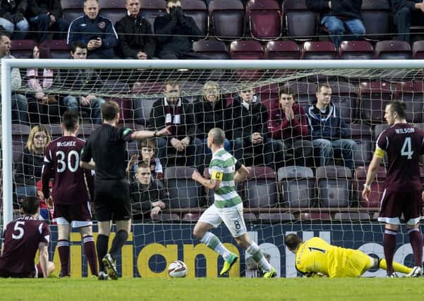 Hearts' dejected players look on as Scott Brown celebrates Celtic's third goal. Pic: Ian Georgeson
