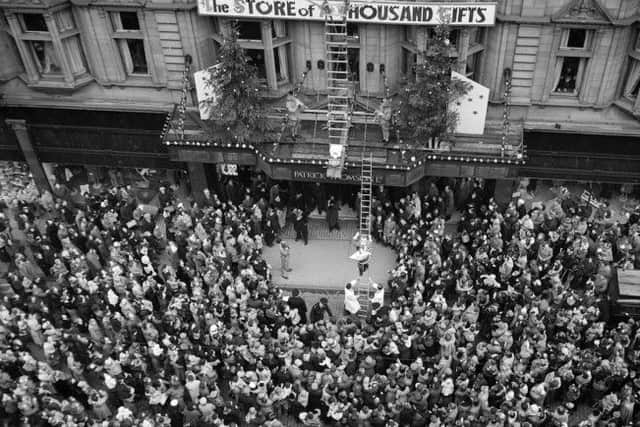 Crowds outside Patrick Thomson's department store as Santa Claus climbs down a golden ladder in November 1955. Picture: TSPL
