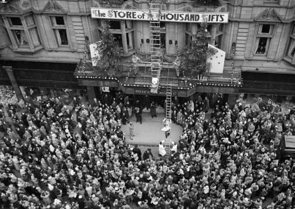 Crowds outside Patrick Thomson's department store as Santa Claus climbs down a golden ladder in November 1955. Picture: TSPL
