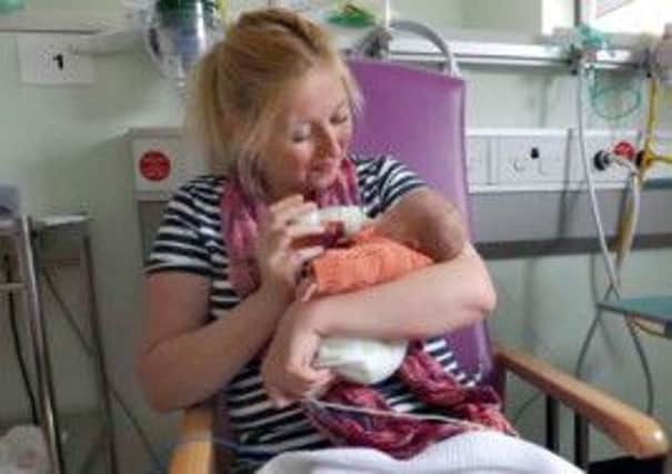 Claire Cressey bottle feeds baby Emily, who was born 24 weeks premature at Simpsons maternity unit at the ERI on February 27. Picture: contributed