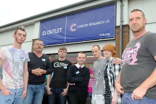 The manager of the cancer research shop, Joe Orrock, right, and staff outside the Corstorphine shop. Picture: Neil Hanna
